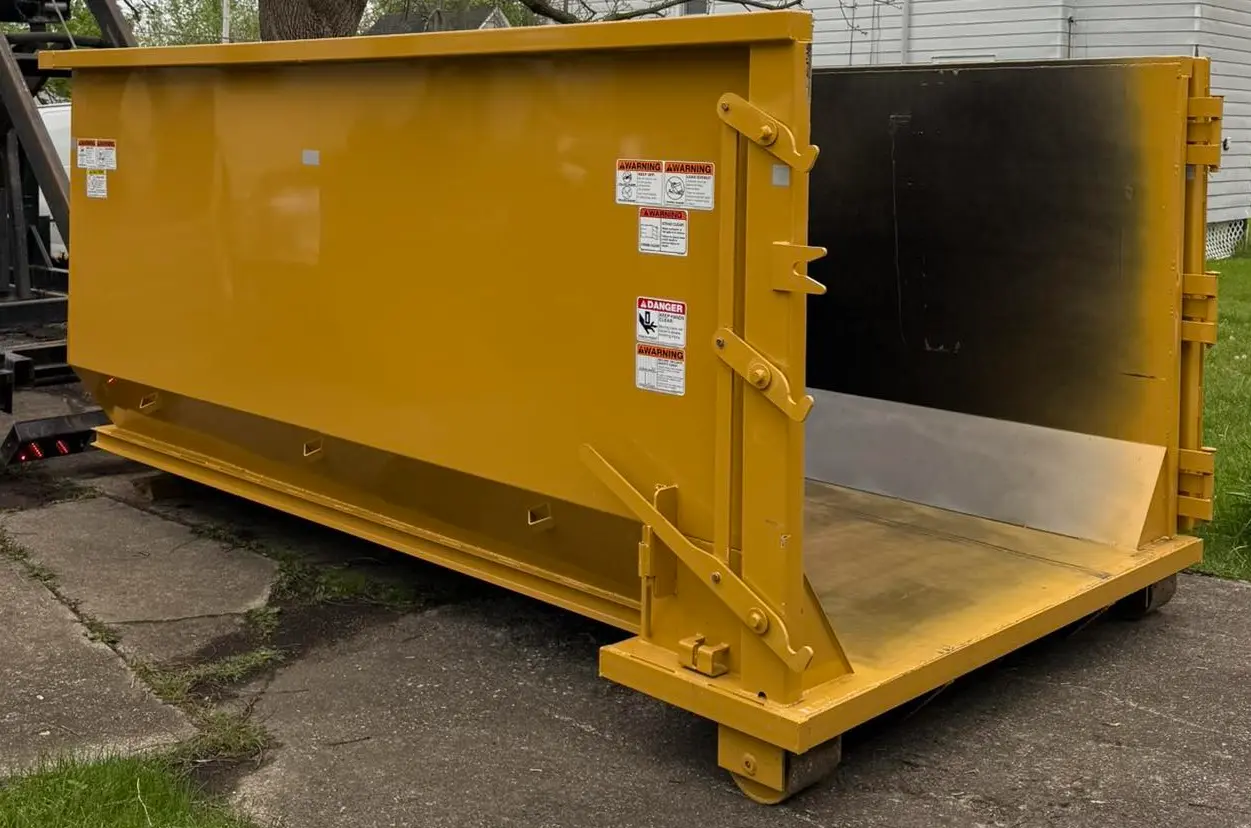 RapidPolk Dumpster Rental yellow dumpster set down at home site with open rear gate ready for use