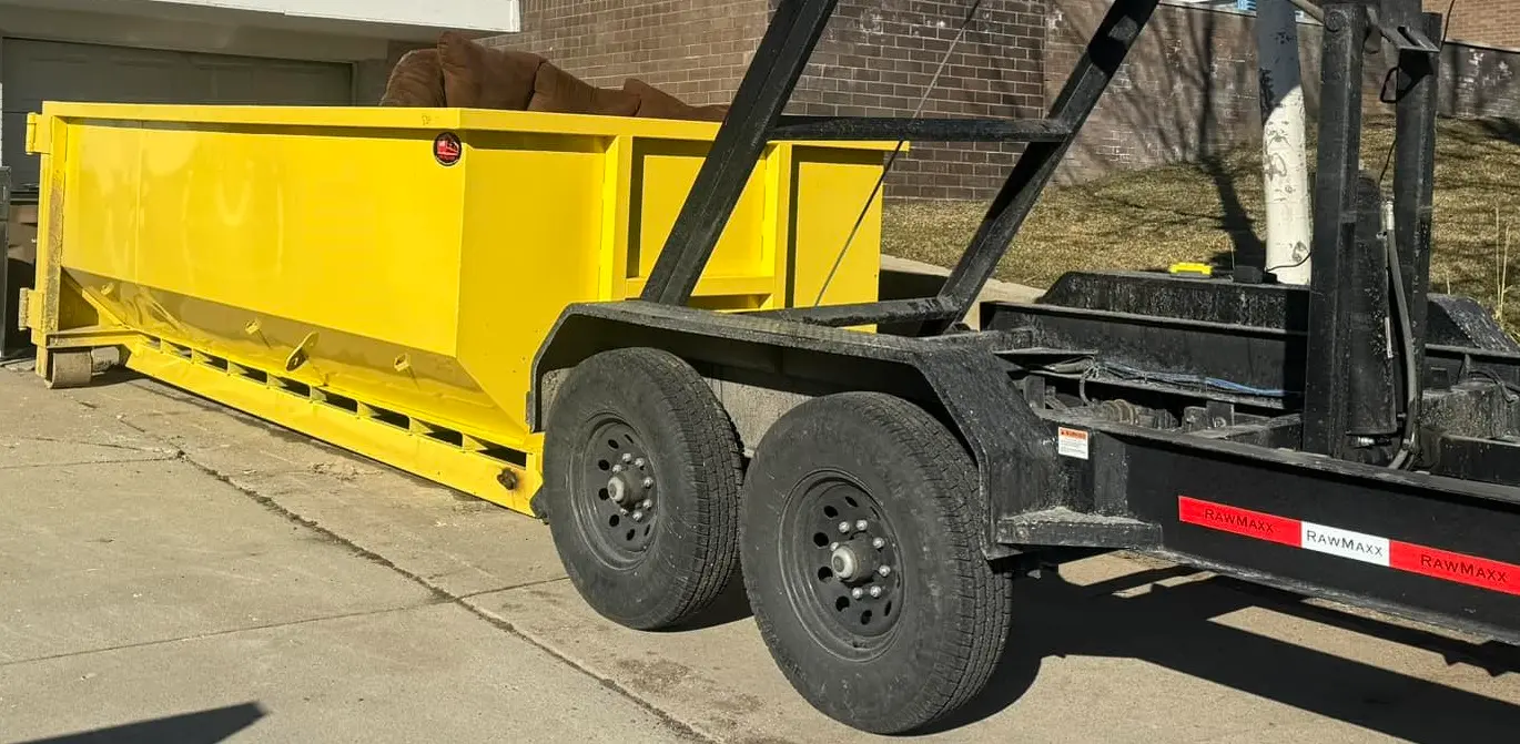 RapidPolk Dumpster Rental yellow dumpster loaded with bulky junk during residential haul away setup