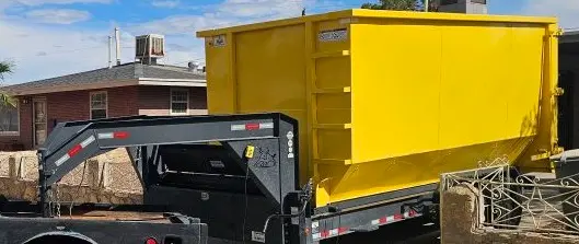 RapidPolk Dumpster Rental gooseneck trailer transporting yellow roll-off dumpster to local home site