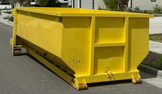 RapidPolk Dumpster Rental places a yellow roll-off dumpster along a residential street in front of homes