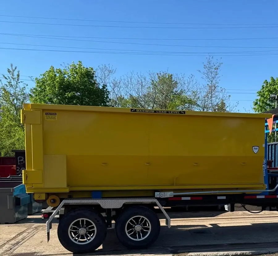 Residential dumpster rental by RapidPolk moves yellow rolloff for home renovation cleanup